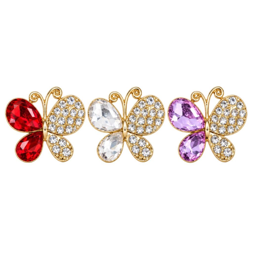 Aplique de borboleta dourada com strass e pedras na cor vermelho, branco e lilás sobre fundo branco.