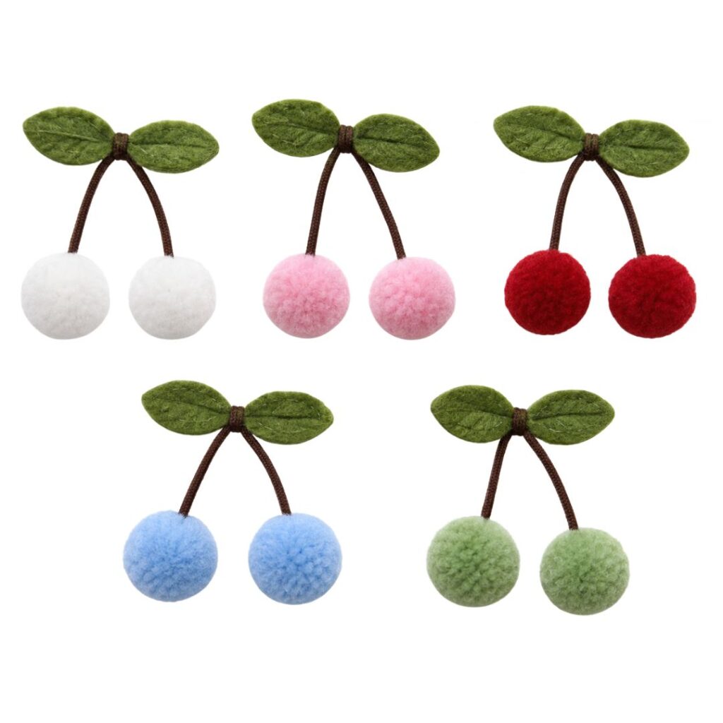 Cinco apliques de cereja com dois pompons, hastes marrons e folhas verdes, nas cores branca, rosa bebê, vermelha, azul-claro e verde-claro.